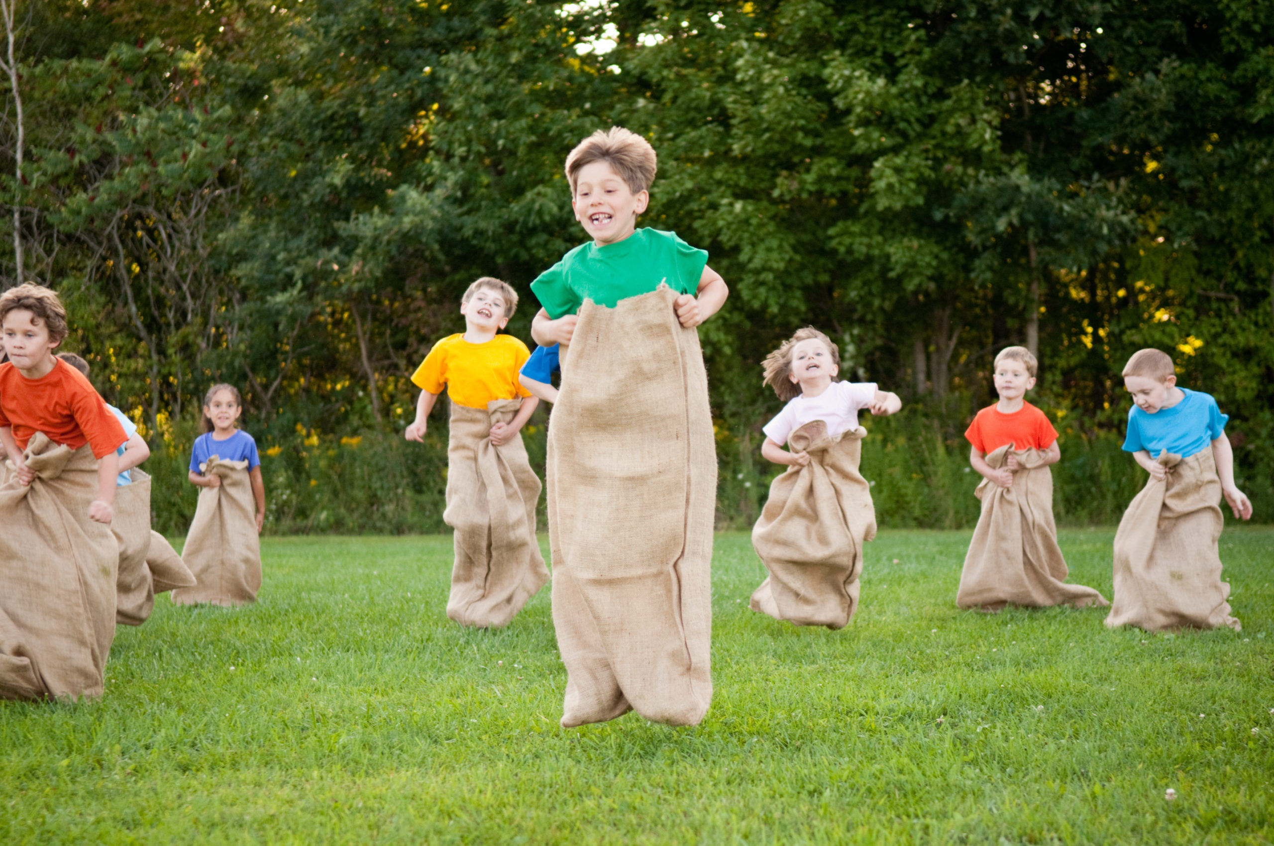 Kids hopping in a sack race on the grass